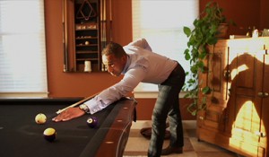 A man playing pool in his living room.