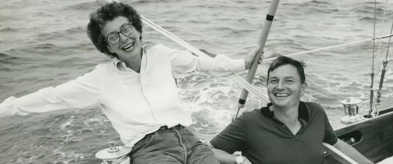 A man and woman sitting on the back of a boat.