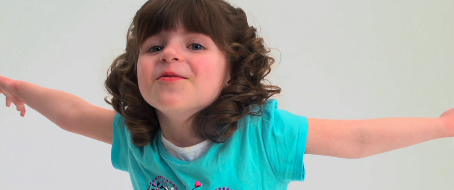 A little girl with brown hair and blue shirt.