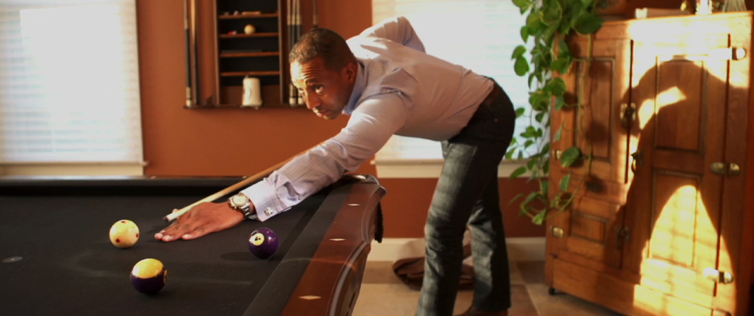 A man leaning over the edge of a pool table.