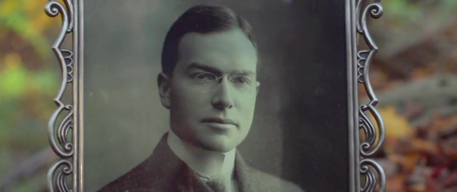 A man with glasses is in an old photo.
